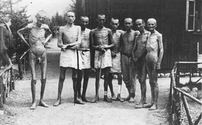 Das Bild zeigt eine Gruppe von KZ-Häftlingen, teilweise unbekleidet, völlig abgemagert